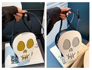 Detailed close-up of skull-shaped crossbody bags featuring gold and silver glitter eye accents