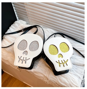 Close-up of skull-shaped crossbody bags featuring glittery gold and silver detailing