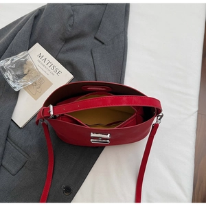 Close-up of red leather handbag interior with yellow lining and silver metal square lock