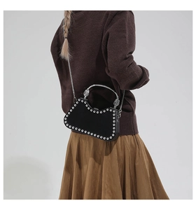 Detail of black velvet box bag with silver studs and a metallic top handle