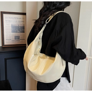 Detail of a large cream Hobo bag featuring glossy PU leather and adjustable strap buckle