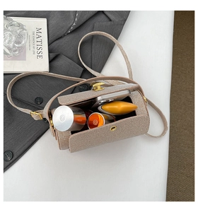 Interior view of beige woven cylinder bag showing large capacity for phone and lipstick