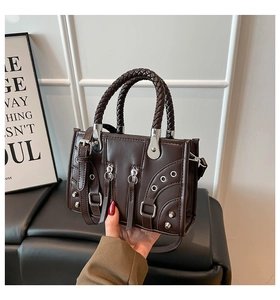 Close-up of deep coffee leather biker bag with silver studs and woven handles