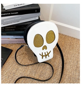 Close-up of a white skull-shaped crossbody bag featuring glittery gold sequin eyes