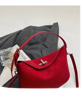 Detail of red crescent shoulder bag with suede finish and silver twist lock closure