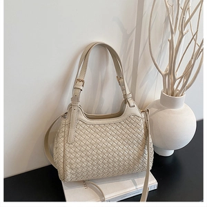 Détail du sac hobo tissé crème avec texture tressée et bandoulière réglable chic