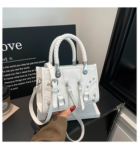 Detail of white PU leather bag with woven handle, silver studs and metal buckles