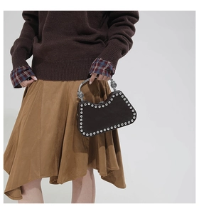 Detail of vintage tote bag with silver rivets and embossed metal handle for a stylish look