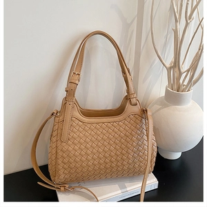Détails de la texture en cuir tressé et poignées réglables du sac à main beige