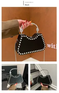 Detail of black rivet box bag with ornate silver metal handle and chain strap