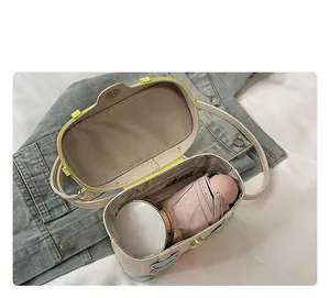 Top view showing the spacious brown interior of a mini box bag with an umbrella and makeup