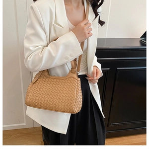 Sac hobo tissé camel moderne porté avec un blazer blanc pour un look urbain chic