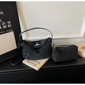 Detail of black suede dumpling bag set with silver twist-lock and internal pouch
