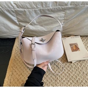 Close-up of light pink pillow bag with silver turn-lock and dual leather straps