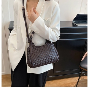 Détails de la texture tissée marron foncé et de la bandoulière réglable du sac à main chic