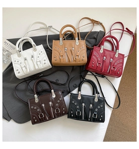 Detail view of motorcycle style handbags showing metal rivets and belt buckles