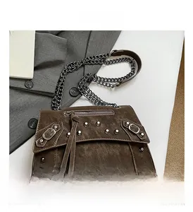 Detail shot of vintage dark brown studded motor bag with chain strap and rivets