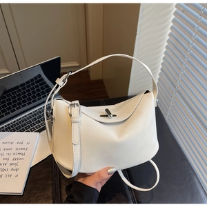 White dumpling tote bag with silver twist lock shown in a minimalist office setting