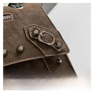 Detail of retro brown leather bag with lychee texture and silver rivet studs