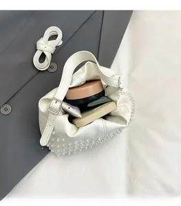 Dettaglio della borsa a secchiello con perle con cosmetici e cellulare all'interno