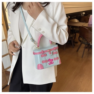 Detail of vintage blue suitcase crossbody bag with pink rabbit graffiti and metal buckles