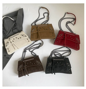 Close-up of studded motorcycle crossbody bags in five colors with metal chain straps