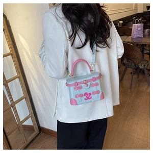 Blue and pink contrast box bag with bunny detail shown styled on a white blazer