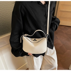 Close-up of white leather Lindy style crossbody bag with silver buckle and shoulder strap