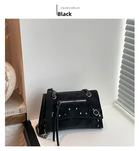 Detail view of black vintage biker bag with silver rivets and long leather tassels