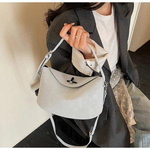 Detail of light grey leather handbag with silver twist lock and slim shoulder strap