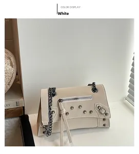 Detail view of off-white rivet chain bag featuring tassels and gunmetal hardware