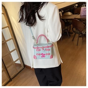 Detail of a mini blue and pink box bag with rabbit motif on a shoulder strap