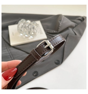 Detailed close-up of dark brown leather strap with polished silver metal buckle and stitching