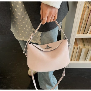 Close-up of light pink leather dumpling bag with silver twist lock and adjustable strap