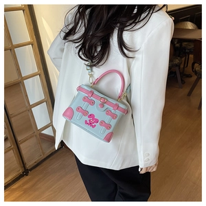 Detail of light blue and pink contrast box bag with cute rabbit pattern and round handle