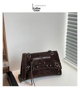 Close-up of vintage brown oil wax leather bag with metallic rivets and chain details
