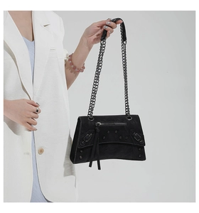 Detail of black motorcycle shoulder bag with rivet accents and metal chain straps