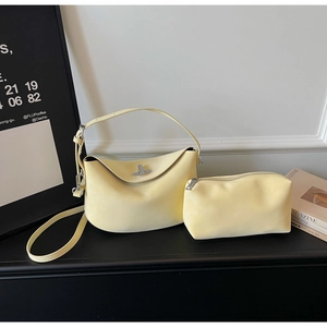 Detail view of butter yellow dumpling bag set with silver twist lock and small pouch