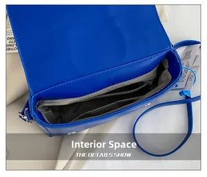 Interior view of bright blue leather crossbody bag showing grey herringbone lining and zipper pocket