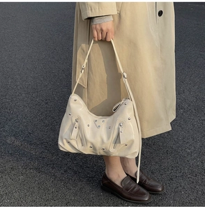 Vue détaillée du sac à bandoulière en cuir souple blanc crème avec clous métalliques