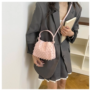 Dettaglio della borsa a secchiello rosa in ecopelle con perle e chiusura a coulisse