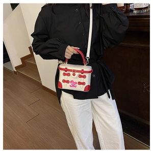 Detail of a retro box-shaped handbag with red edges and a cute pink rabbit graphic