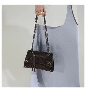 Detail of dark brown rivet chain bag showing vintage motorcycle style and metal buckles