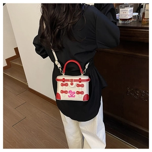Detail of red and white box bag with cartoon rabbit print and metal buckle