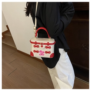 Detail of a retro box-shaped crossbody bag featuring red and white contrast and rabbit print