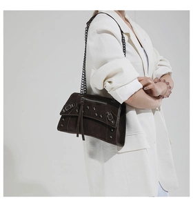 Detail of dark brown hourglass motorcycle bag with silver rivets and metal chain strap