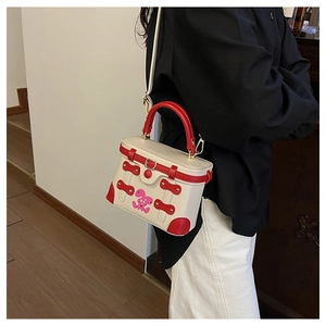 Detail shot of the contrast color box bag featuring pink cartoon rabbit and red handle
