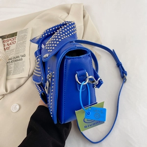 Blue motorcycle jacket style crossbody bag with silver rivets and zipper details