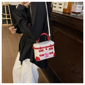 Detail of white box bag featuring a pink cartoon rabbit and contrast red leather trim
