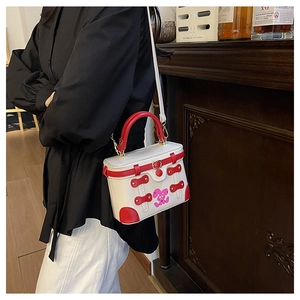Detail of red and white contrast box bag with cartoon rabbit and gold hardware